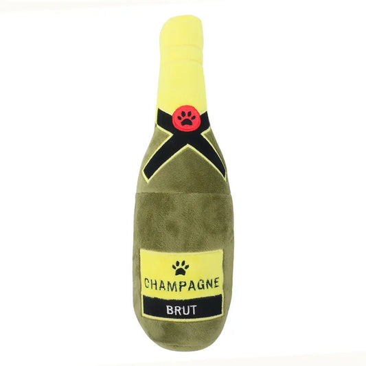 Plush toy shaped like a champagne bottle with a yellow label on a white background